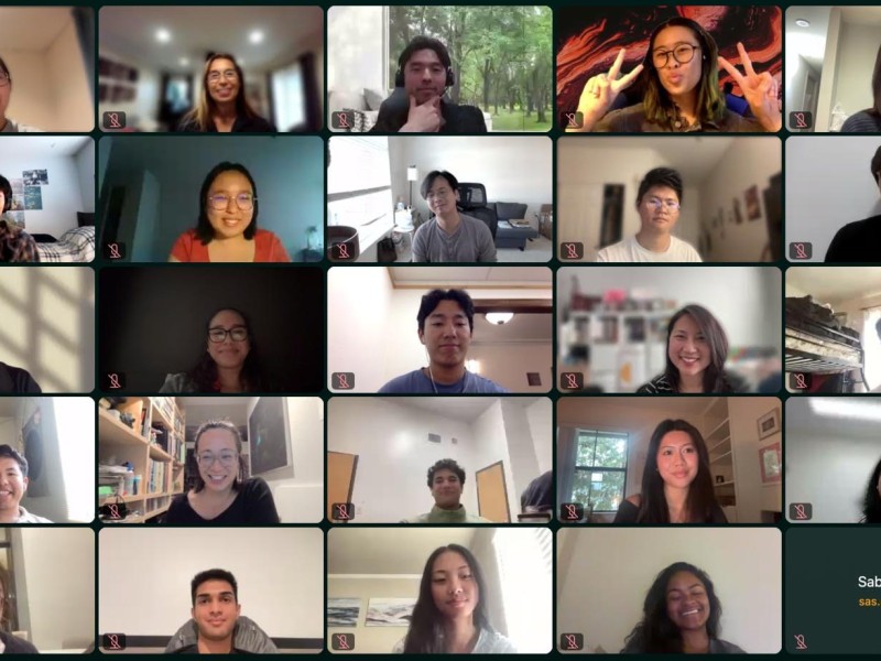 A screenshot of a virtual video call showing many participants arranged in a grid. Each person appears in their own video tile, smiling or listening during the meeting. The setting suggests an online cohort or group discussion, with participants joining from different locations in a collaborative, community-oriented space.